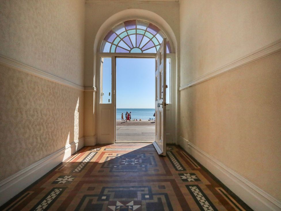 A hallway with door opening to the sea at 123 On The Sea - The Cubby in Weymouth