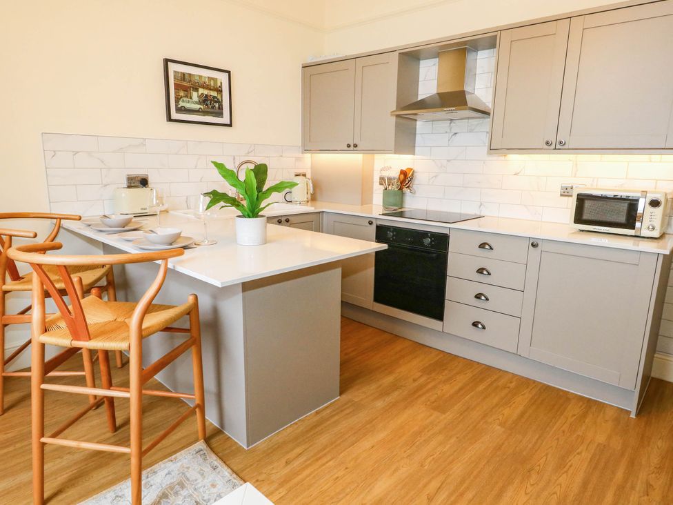 A kitchen with cabinets and countertop at 123 On The Sea - The Cubby in Weymouth