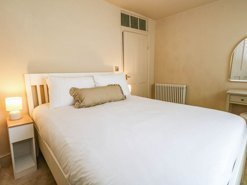 A bedroom with a bed and lamp at 123 On The Sea - The Cubby in Weymouth