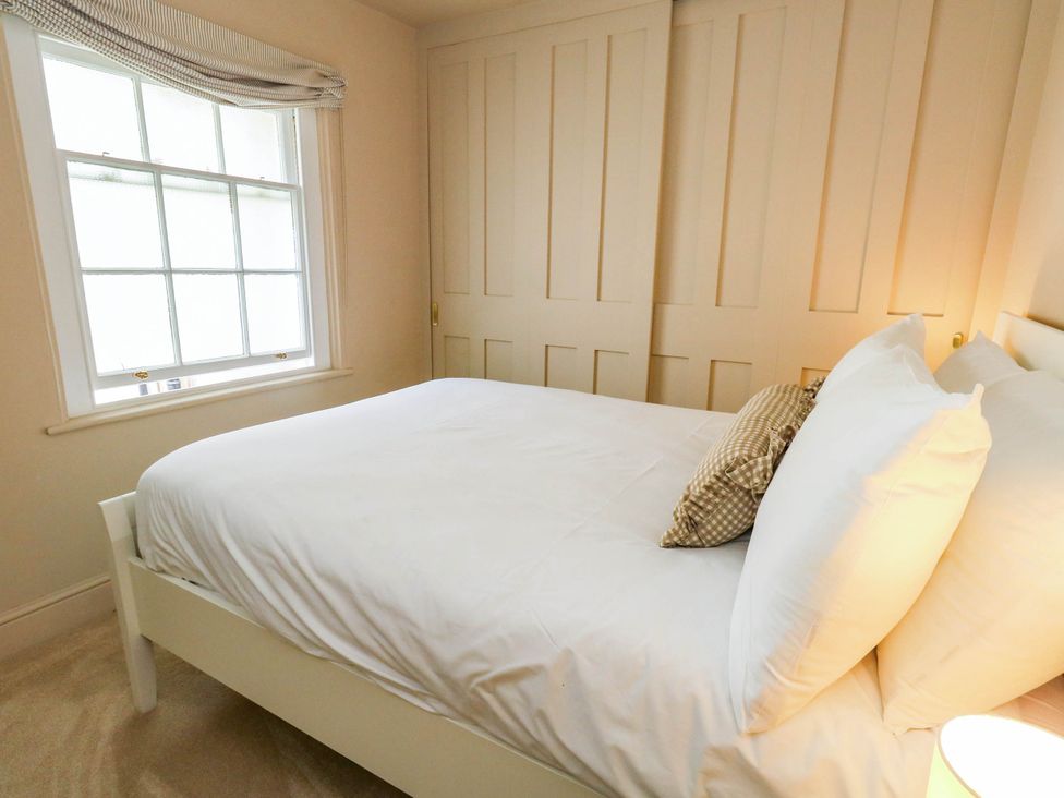 A bedroom with a bed and window at 123 On The Sea - The Cubby in Weymouth