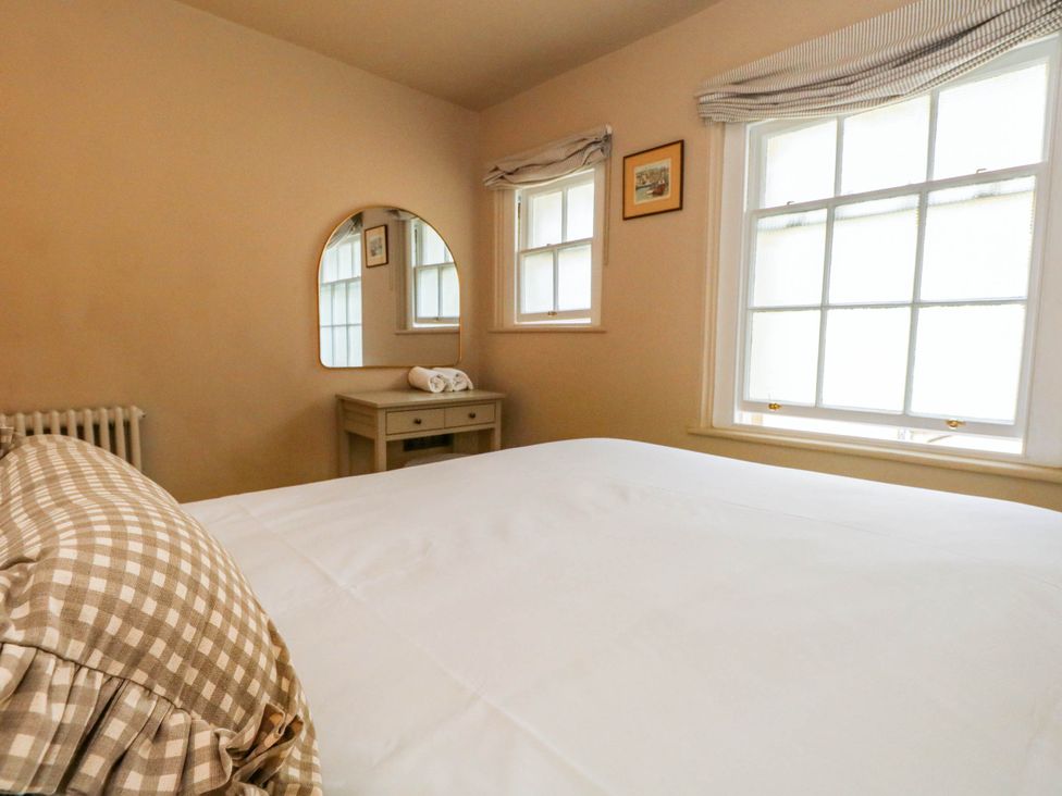 A bedroom with a bed and nightstand at 123 On The Sea - The Cubby in Weymouth