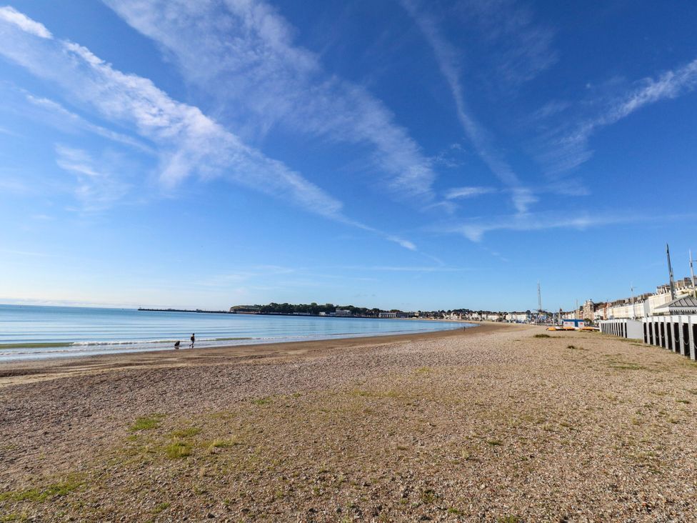 A beach with people by the water at 123 On The Sea - The Cubby in Weymouth