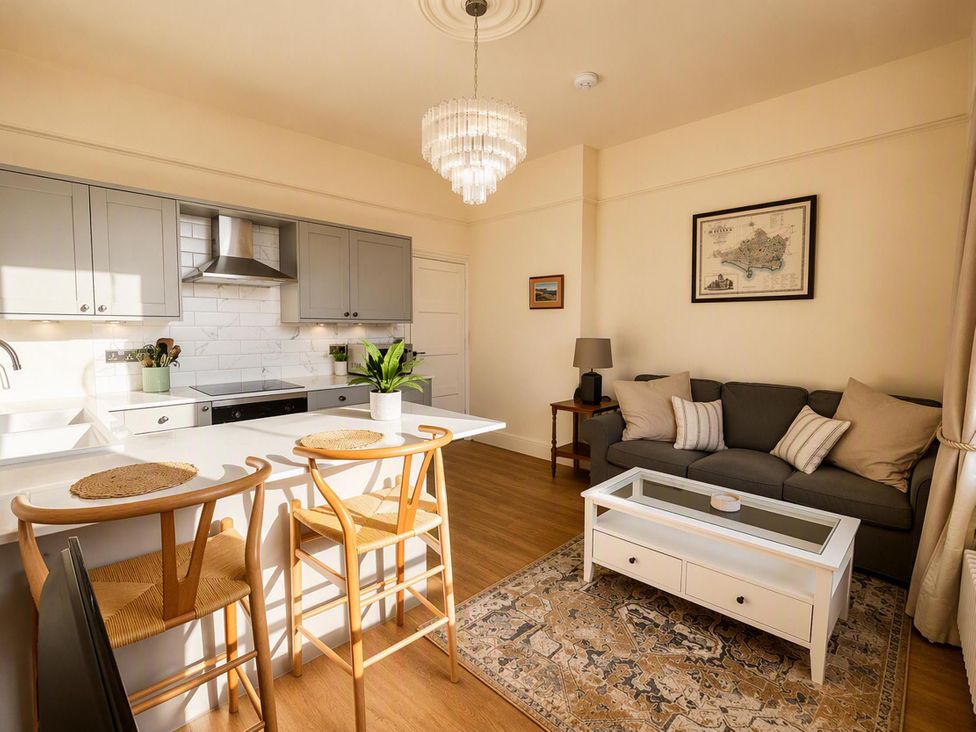 A living room with a kitchen island and stools at 123 On The Sea - The Cubby, Weymouth