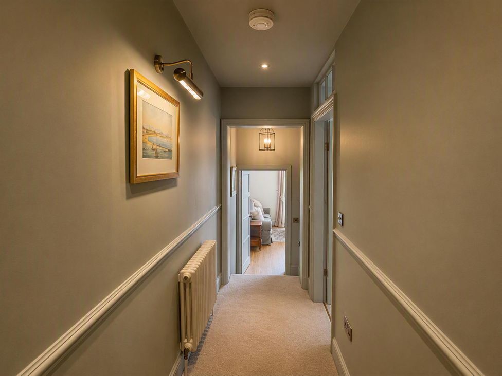 A hallway with a painting and a light fixture at 123 On The Sea - The Cubby, Weymouth