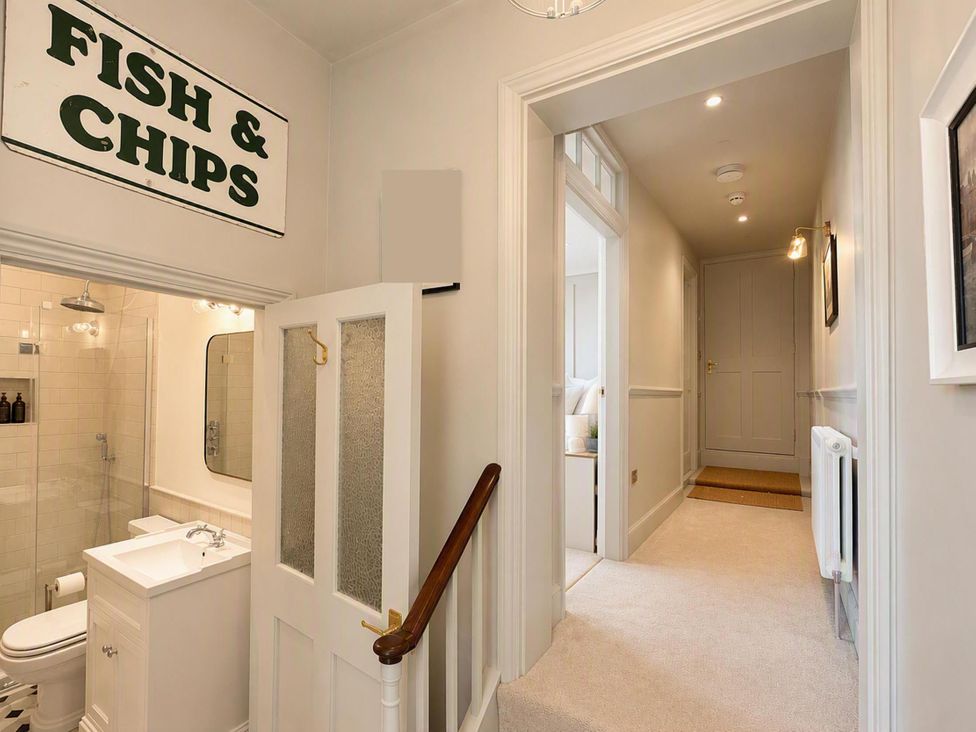 A bathroom with shower, toilet, sink and light fixture at 123 On The Sea - The Cubby in Weymouth