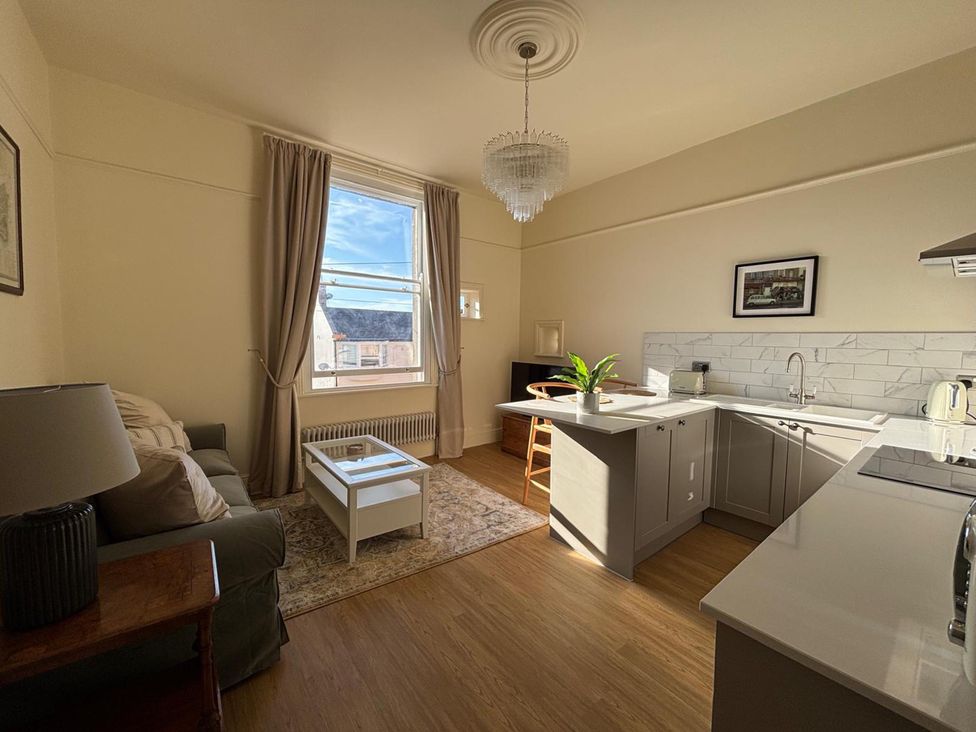 A kitchen with a sofa and breakfast bar at 123 On The Sea - The Cubby, Weymouth