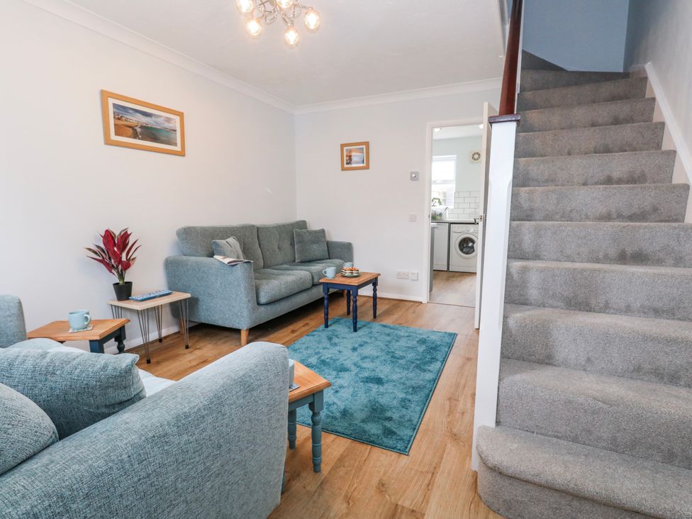 A living room with a staircase and furniture at 23 The Maltings in Weymouth