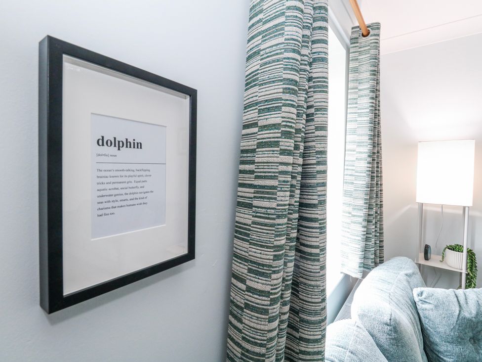 A living room with a framed poster and curtains in Weymouth