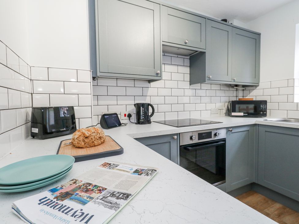 A kitchen with cabinets, oven, microwave, and bread at 23 The Maltings in Weymouth