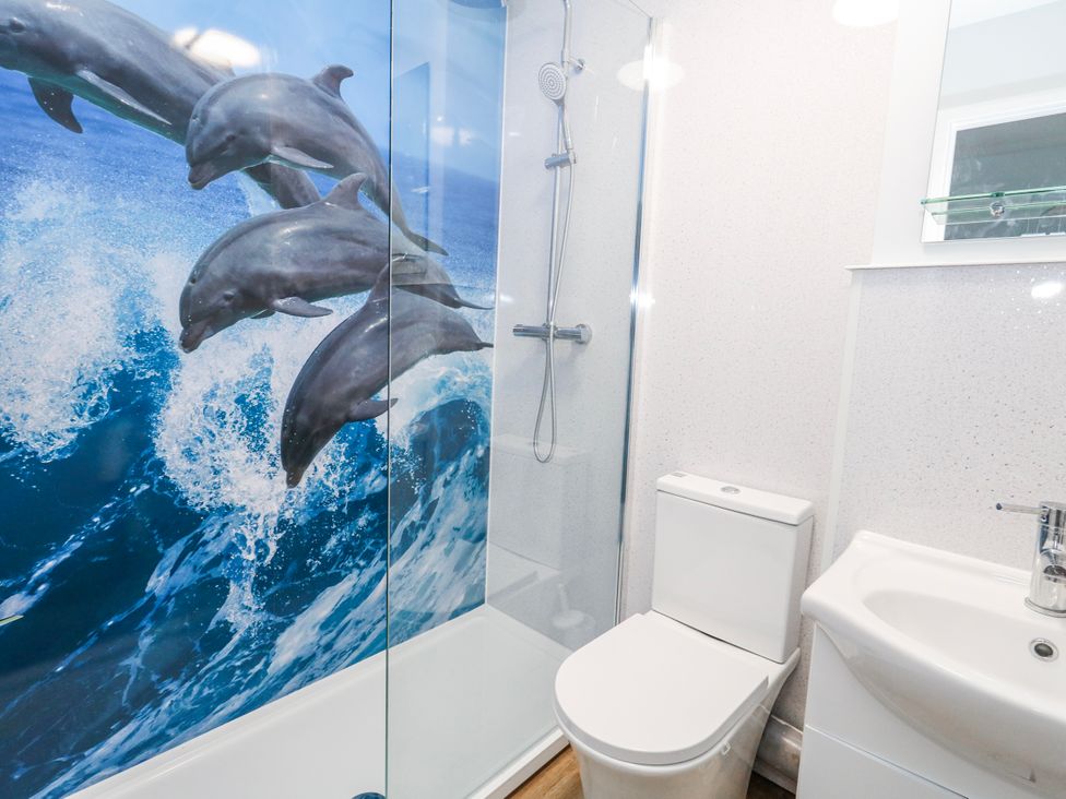 A bathroom with a shower, toilet, and sink at 23 The Maltings in Weymouth