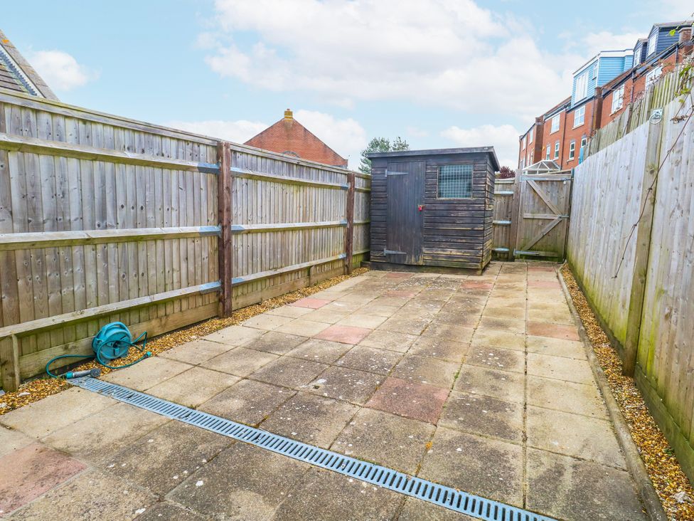 A garden with a shed and paving stones at 23 The Maltings in Weymouth