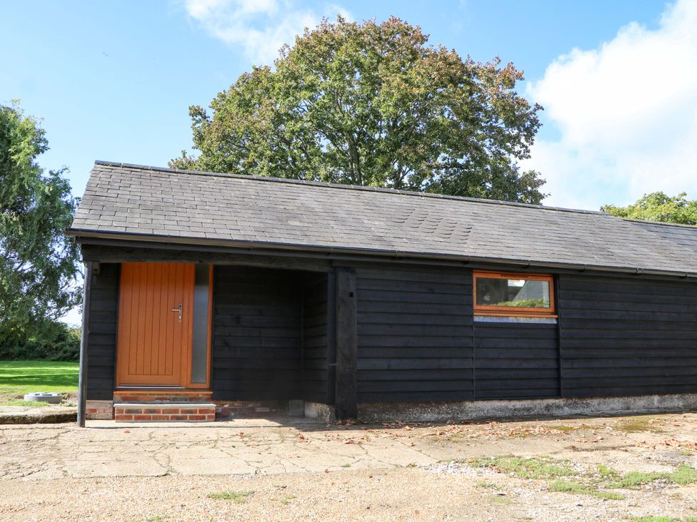 A black wooden building with a door and window at The Old Parlour in Southampton