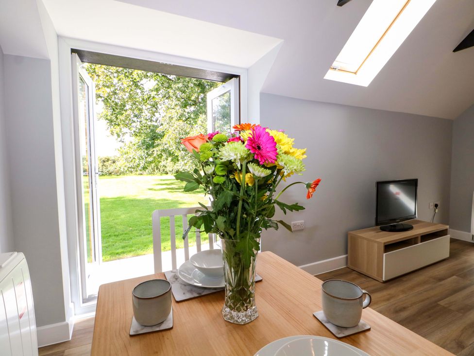 A dining room with a flower vase on a table at The Old Parlour in Southampton