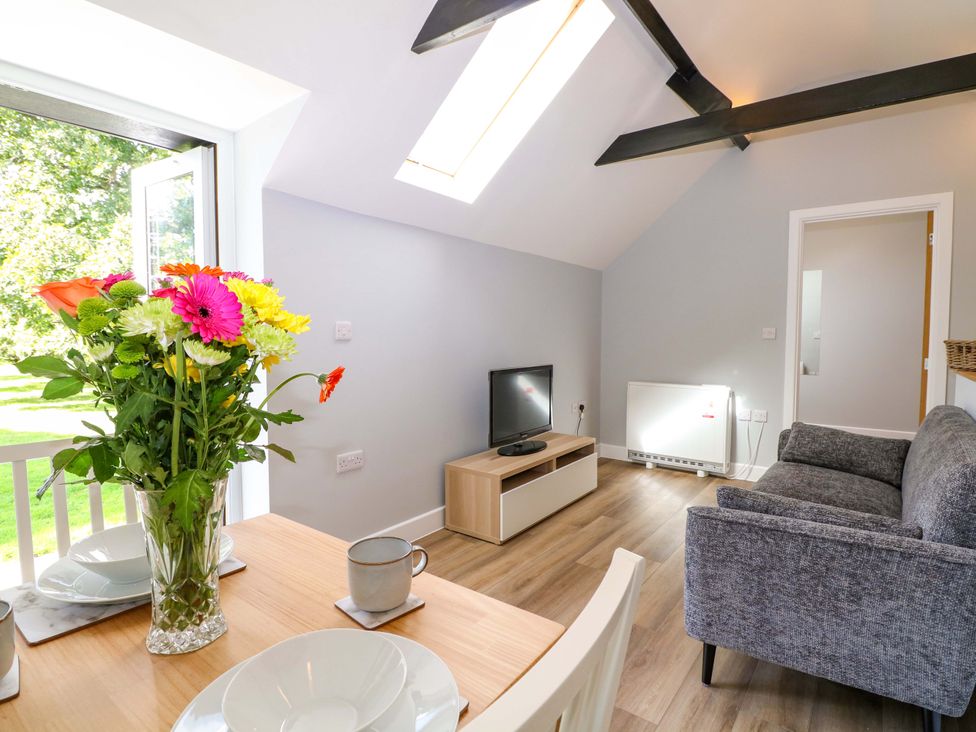 A living room with a flower vase and a TV at The Old Parlour in Southampton