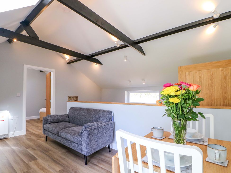 A living room featuring a sofa, dining table, and flowers at The Old Parlour in Southampton