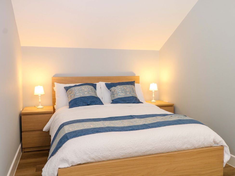 A bedroom with a bed and nightstands at The Old Parlour in Southampton