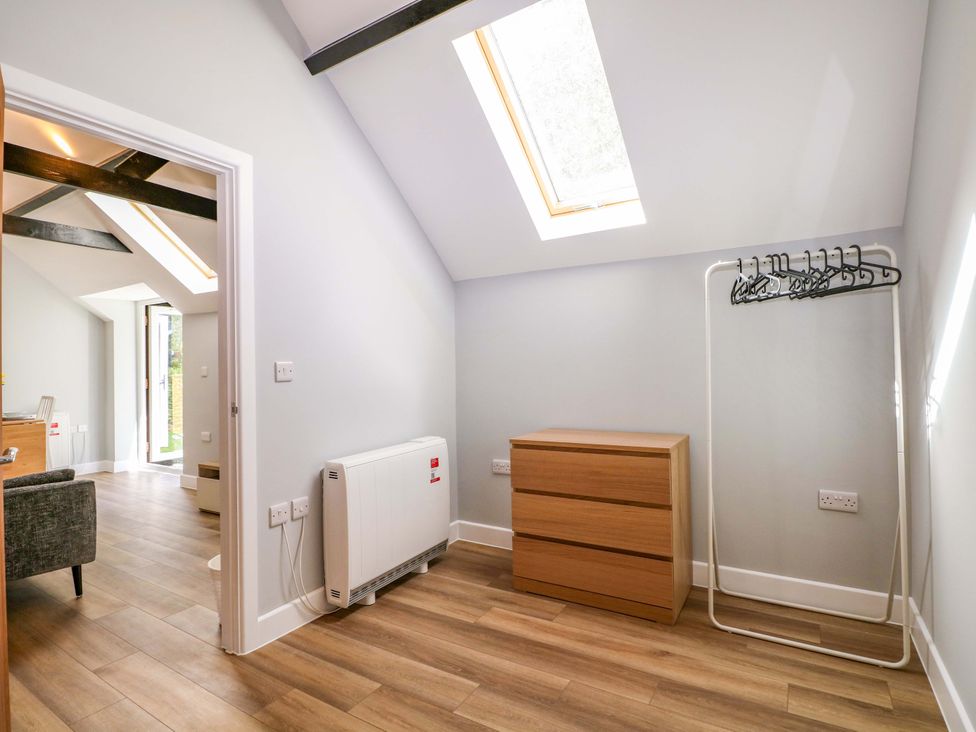 A bedroom with a dresser and a clothes rack at The Old Parlour in Southampton