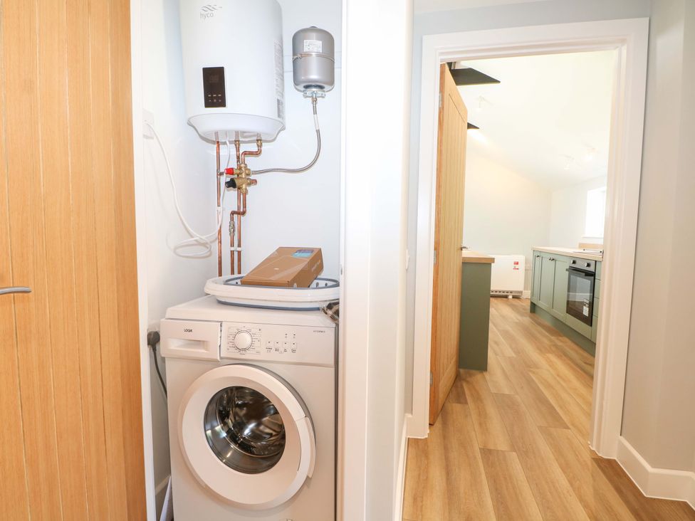 A laundry room with a washing machine and boiler at The Old Parlour in Southampton