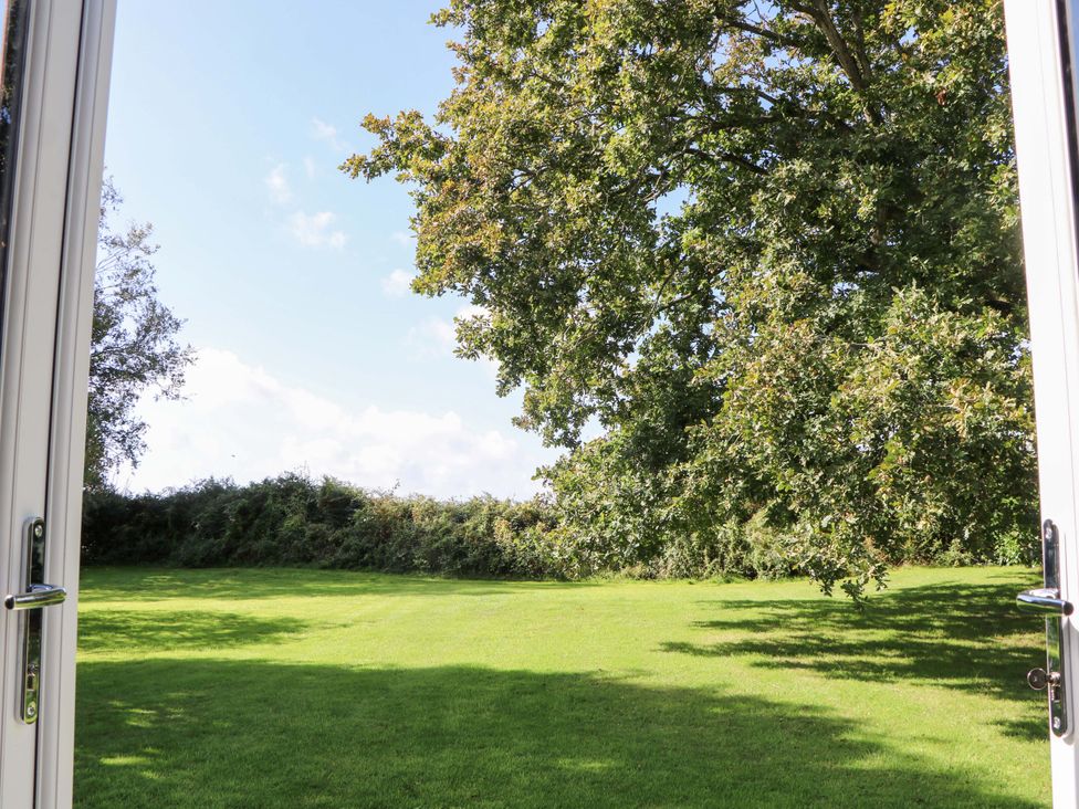A garden view with grass and trees at The Old Parlour Southampton