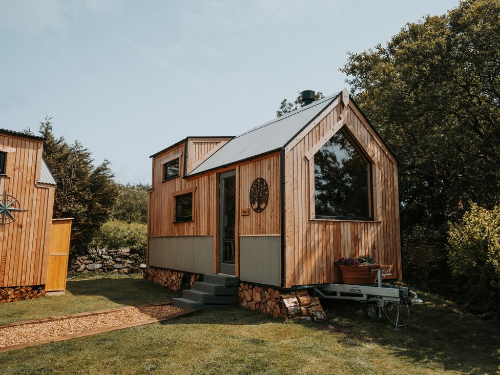 A wooden cabin with large windows and steps at Driftwood in Carreglefn near Llanfechell
