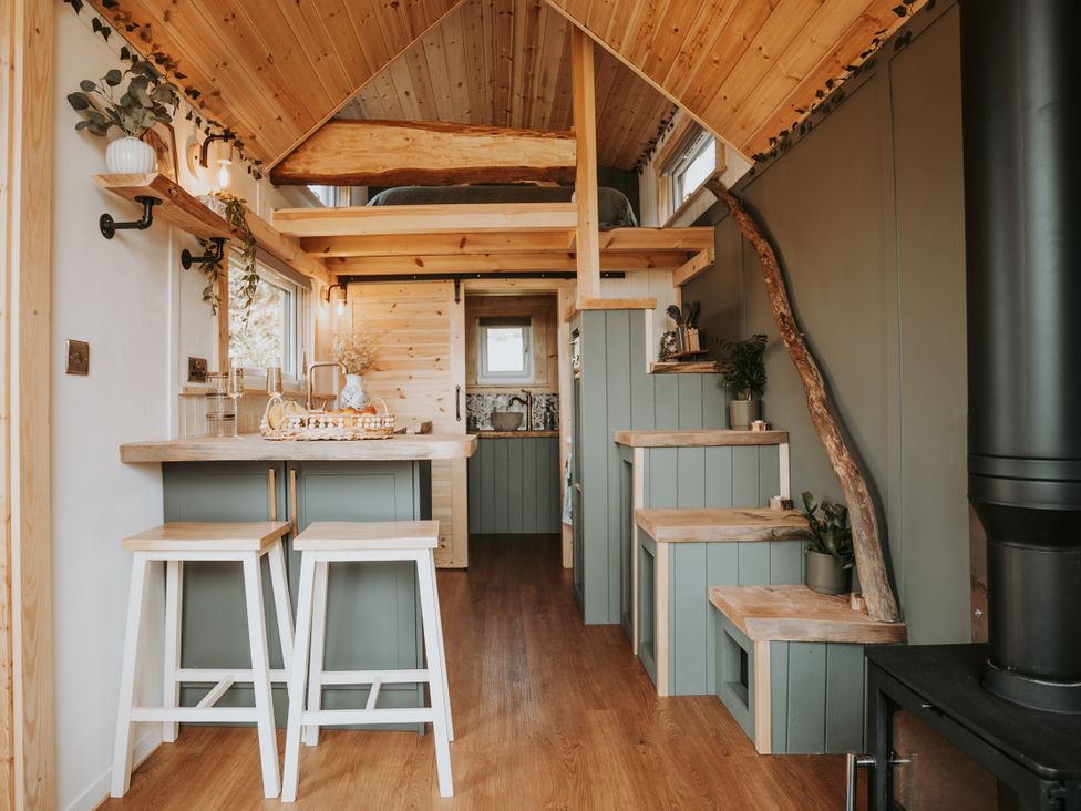 A kitchen with stools and wooden stairs at Rowan in Carreglefn near Llanfechell