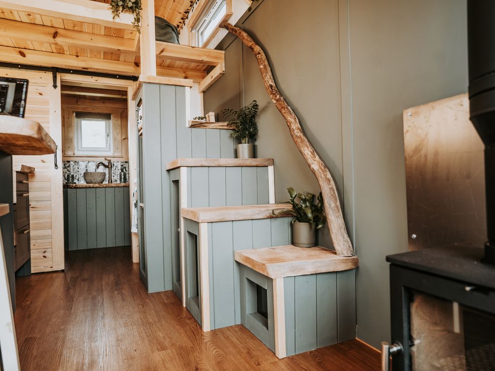 A kitchen with a staircase leading to an upper level at Rowan in Carreglefn near Llanfechell