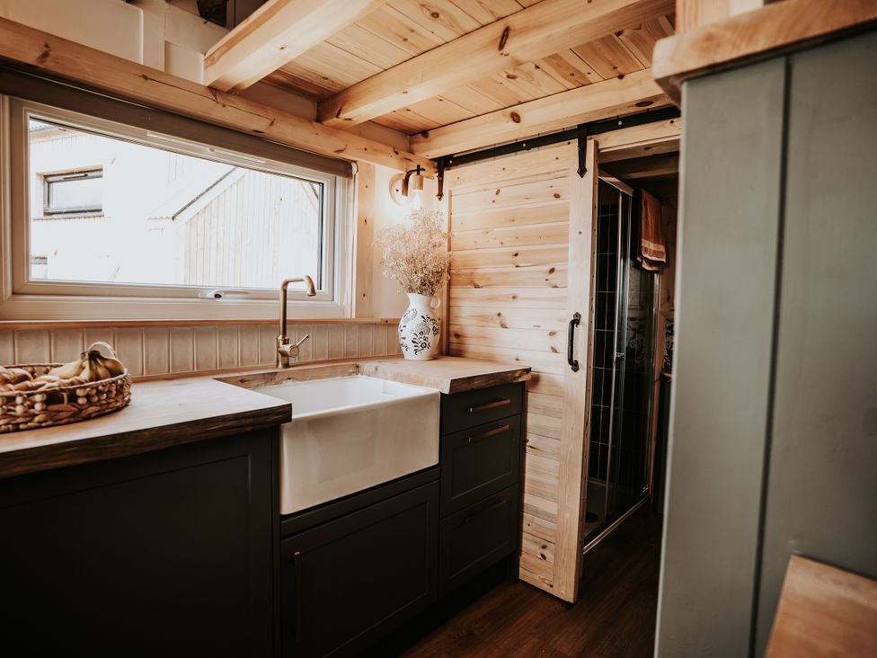 A kitchen with a sink and cabinets at Rowan in Carreglefn near Llanfechell