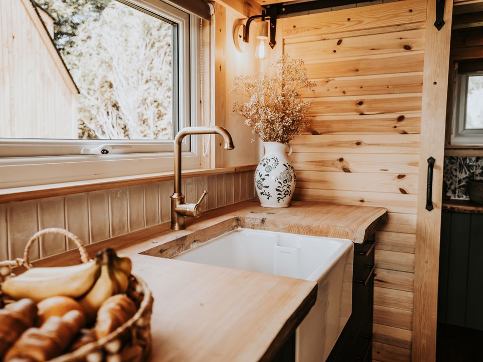 A kitchen with a sink and wooden counter at Rowan in Carreglefn near Llanfechell