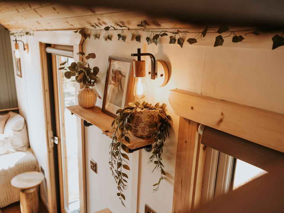 A living room with a light fixture and shelf at Rowan in Carreglefn near Llanfechell