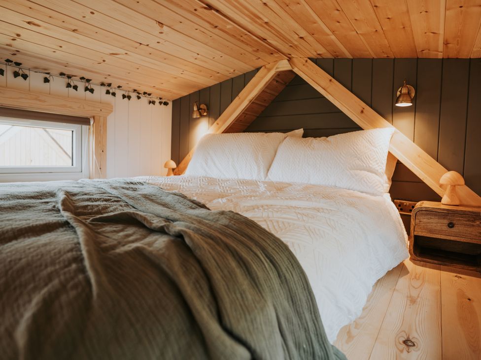 A bedroom with a bed and nightstand at Rowan in Carreglefn near Llanfechell