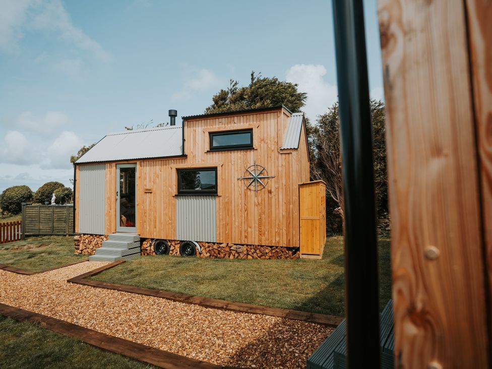 A tiny house with wooden exterior and steps at Rowan in Carreglefn near Llanfechell