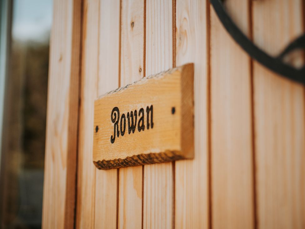 A wooden sign with the name Rowan at Rowan in Carreglefn near Llanfechell