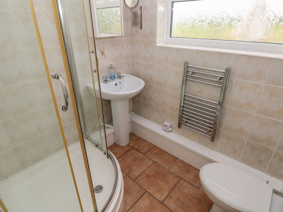 A bathroom with a shower, sink and toilet at Chalet 26 in Scurlage