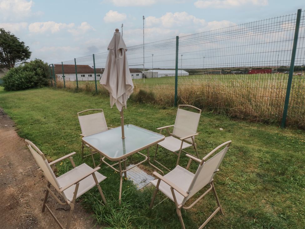 An outdoor patio with a table and chairs at Chalet 26 in Scurlage