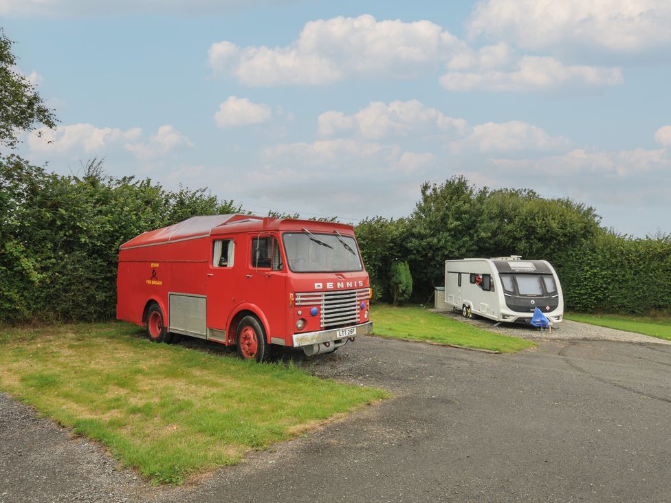 A red truck and a caravan parked on grass at Dashing Dennis - 22 Chapmanswell near Launceston