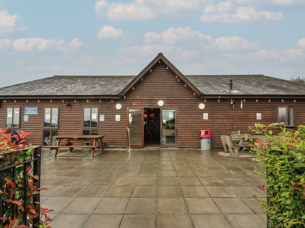 A wooden building with outdoor seating area at Dashing Dennis - 22 in Chapmanswell near Launceston