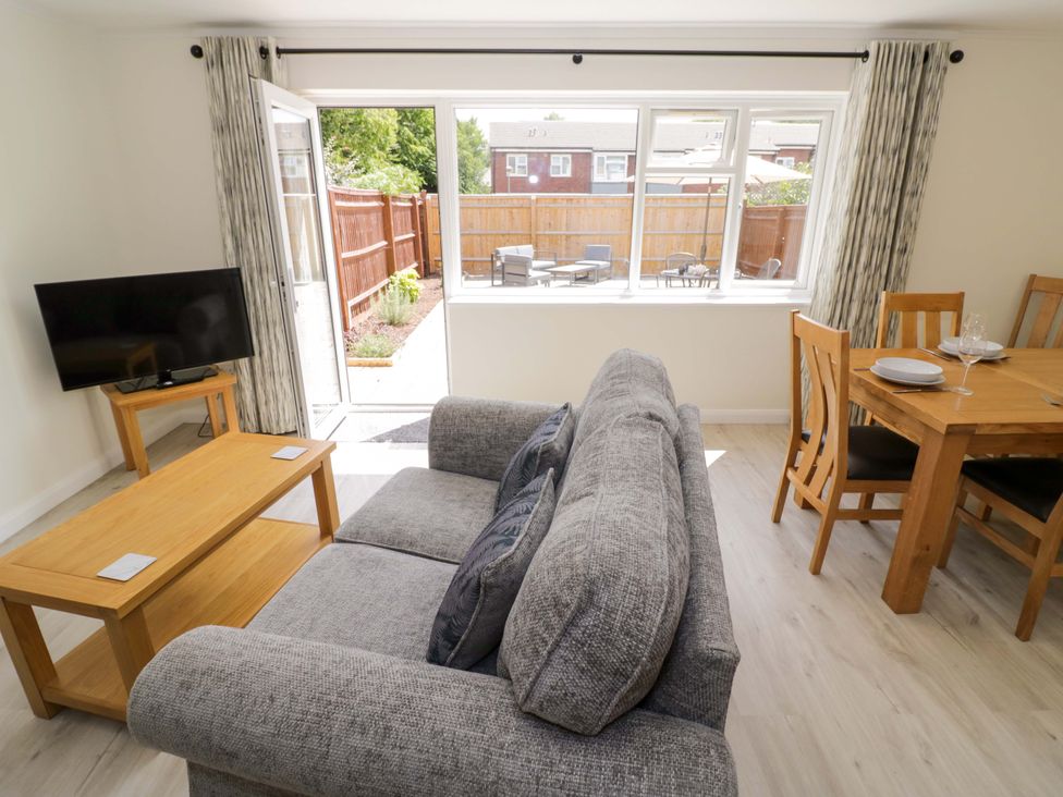 A living room with a sofa and dining table at 22 Old Chapel Close Kidlington