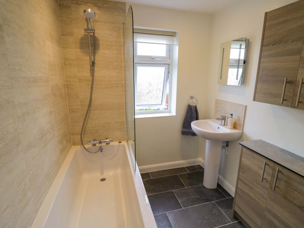 A bathroom with a bathtub and sink at 22 Old Chapel Close Kidlington