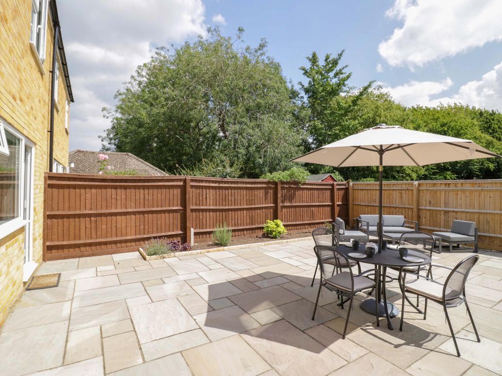 A garden with a table and chairs under an umbrella at 22 Old Chapel Close in Kidlington