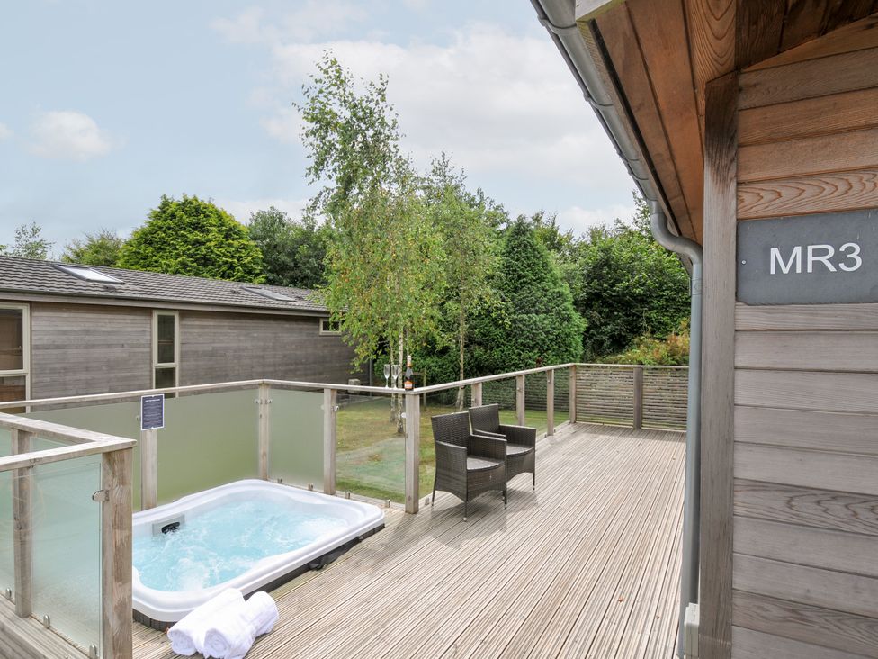 An outdoor area with a hot tub and seating at 3 Meadow Retreat in Liskeard