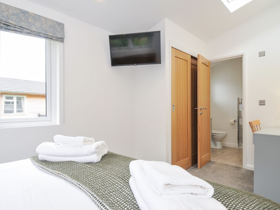 A bedroom with a bed and television at 3 Meadow Retreat in Liskeard