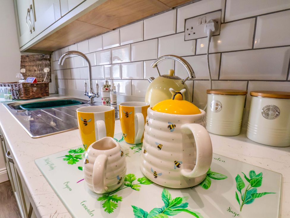 A kitchen counter with a kettle, teapot, mugs, and sugar bowl at Postman’s Lodge in Middlesbrough