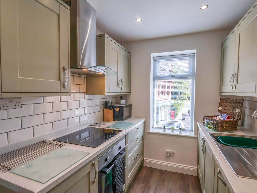 A kitchen with cabinets and a window at Postman’s Lodge in Middlesbrough