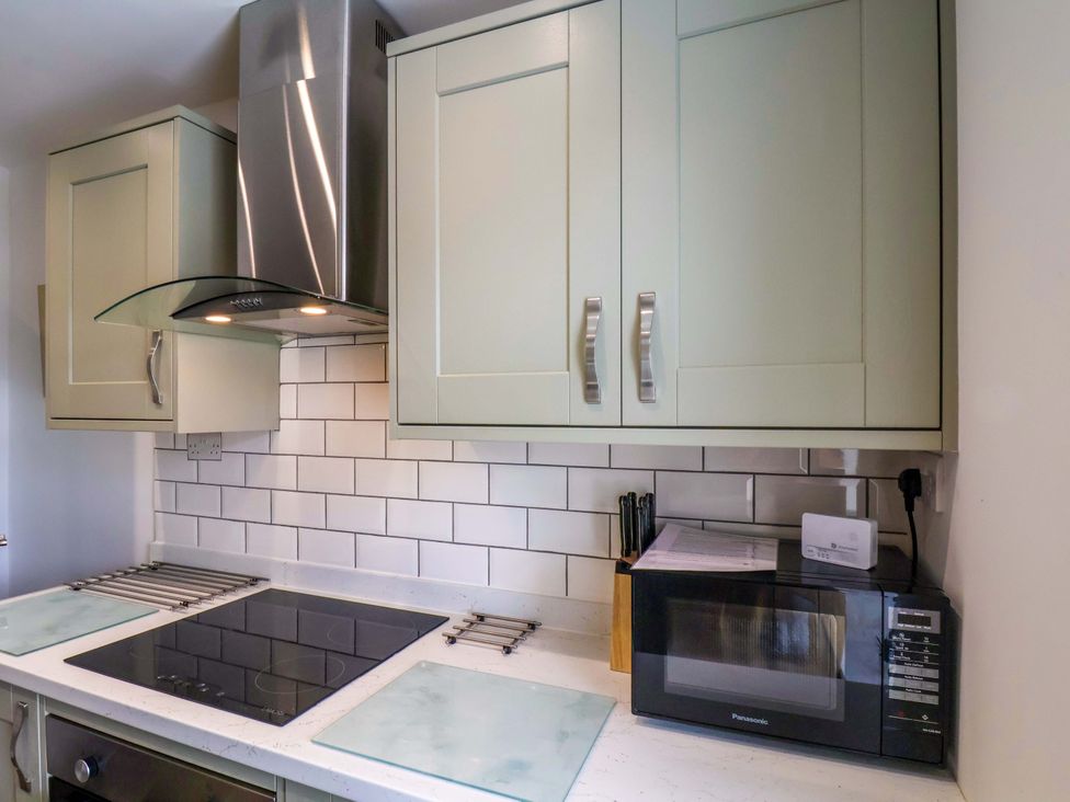 A kitchen with cabinets and a microwave at Postman’s Lodge in Middlesbrough