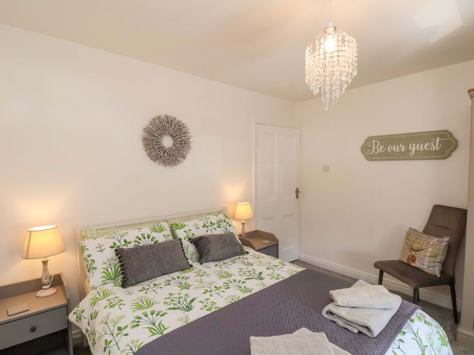 A bedroom with a bed, nightstand, and decoration at Postman’s Lodge in Middlesbrough