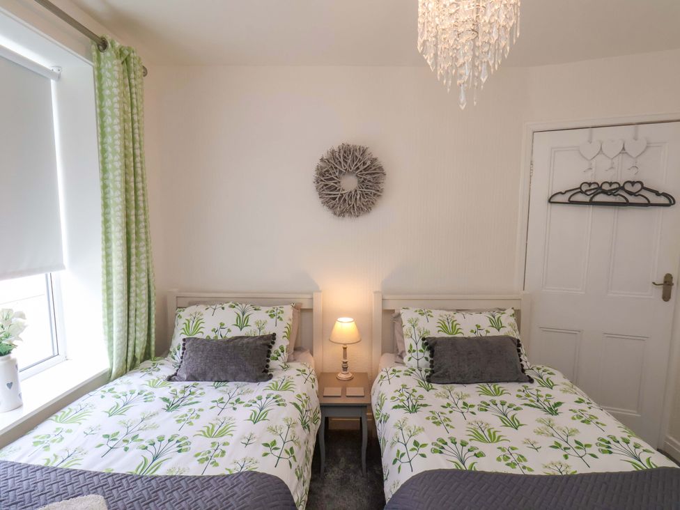 A bedroom with two beds and a nightstand at Postman’s Lodge, Middlesbrough