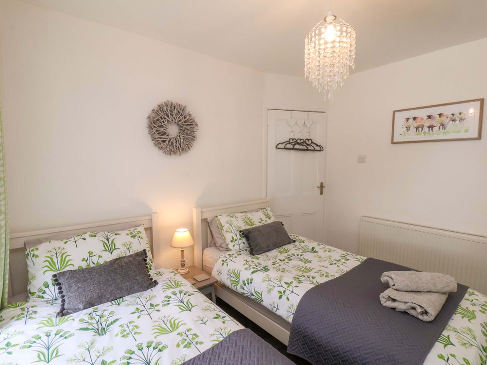 A bedroom with twin beds and a lamp at Postman’s Lodge in Middlesbrough