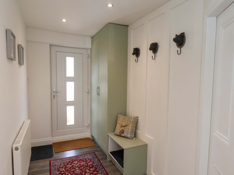 A hallway with a front door and coat hooks at Postman’s Lodge in Middlesbrough