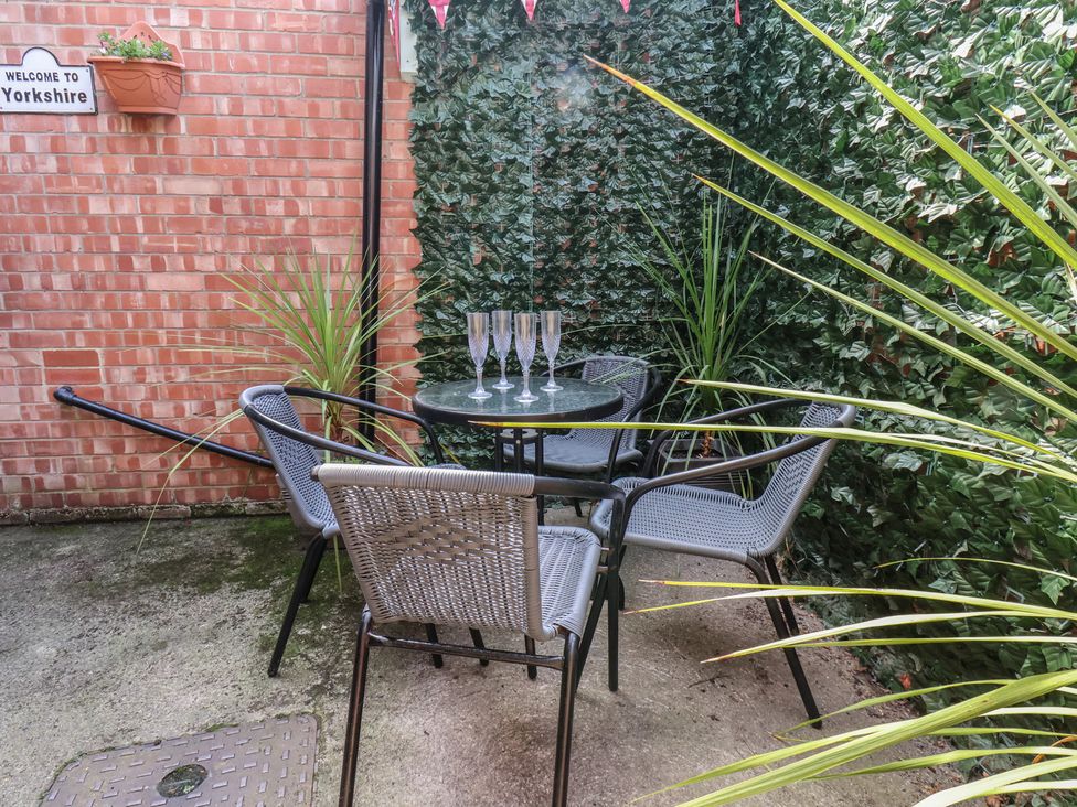 A table with glasses and chairs in a garden at Postman’s Lodge in Great Ayton