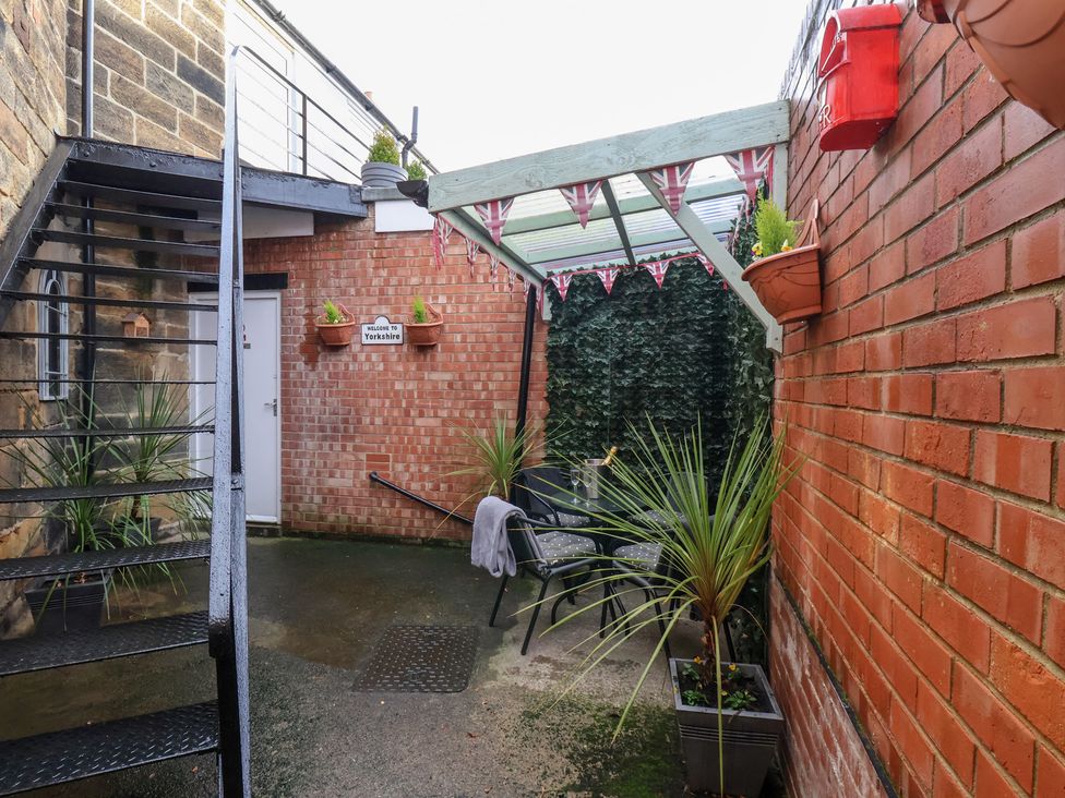 An outdoor area with stairs, a chair, and plants at Postman’s Lodge in Great Ayton